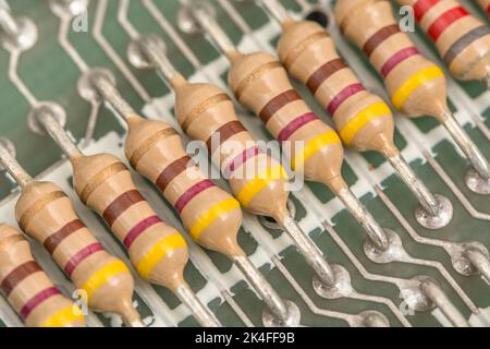 Fila di resistenze a film di carbonio e contatti dei conduttori saldati sulla scheda a circuito stampato di uno spettro ZX Sinclair 1982 16k. Per componenti elettronici. Foto Stock