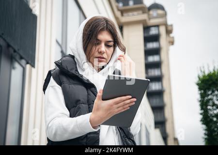 Giovane donna d'affari con un tablet sullo sfondo dell'edificio. Foto Stock