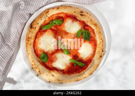 Pizza margarita o margherita con mozzarella a forma di cuore su sfondo bianco, vista dall'alto, menu Foto Stock