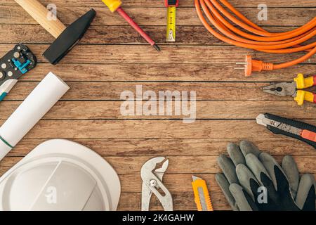Composizione di posa piatta con diversi utensili da costruzione su fondo in legno. Foto Stock