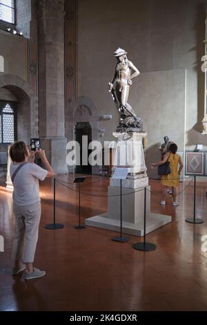 Il visitatore fotografa la Statua del David di Donatello nel Museo del Bargello di Firenze Foto Stock