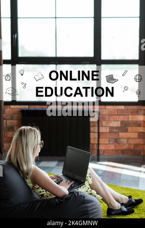 Studio remoto. Formazione online. Corso di lingua. Classe digitale. Studente femminile rilassato guardando video lezione sullo schermo vuoto del notebook in accogliente loft int Foto Stock