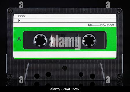 Cassetta compatta vintage retro a con etichetta verde - lato su sfondo nero Foto Stock