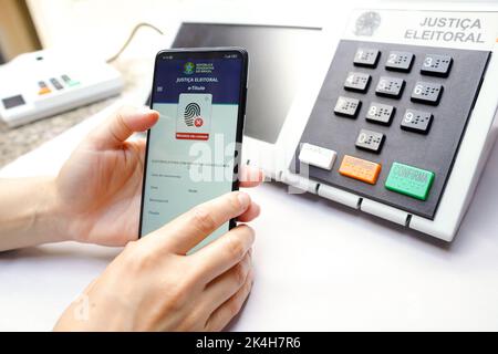 Brasile. 01st Ott 2022. In questa illustrazione, l'app e-Title visualizzata sullo schermo di uno smartphone con un urno elettronico sullo sfondo. (Foto di Rafael Henrique/SOPA Images/Sipa USA) Credit: Sipa USA/Alamy Live News Foto Stock