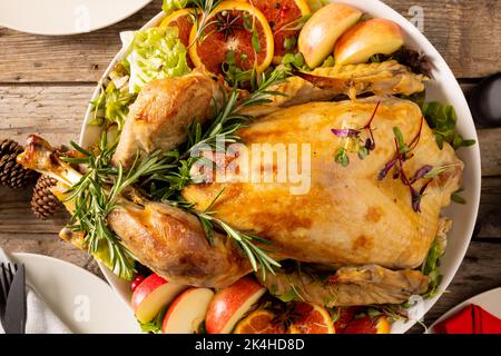 Vista dall'alto del tavolo del ringraziamento con pollo arrosto e decorazione autunnale su legno Foto Stock
