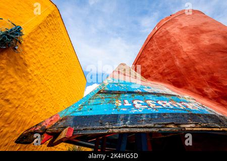 Un vecchio peschereccio capovolto fa ora parte di un edificio in questa fotografia astratta di due edifici di colore diverso. Foto Stock