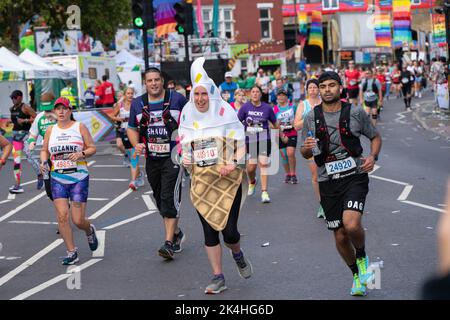 Londra, Regno Unito. 02nd Ott 2022. Maratoneta visto sulla Rainbow Row. Per la prima volta un tratto della rotta della Maratona di Londra è stato trasformato in Rainbow Row per celebrare la comunità LGBTQIA, promuovere l'inclusività e creare un'atmosfera di festa un ascensore a Mile 21. I corridori della maratona passano due fasi con esibizioni musicali e di resistenza e la strada che di solito è chiamata Butcher Row in Limehouse è coperta da bandiere colorate e bunting. Credit: SOPA Images Limited/Alamy Live News Foto Stock