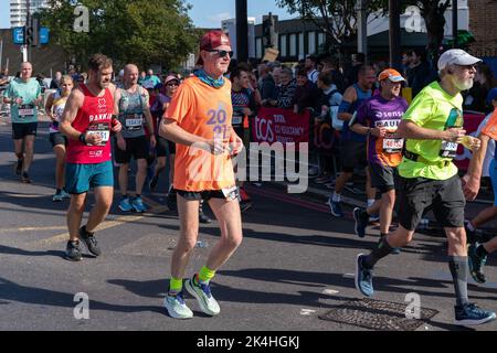 Londra, Regno Unito. 02nd Ott 2022. Chris Evans (Front L) visto durante la Maratona di Londra. Per la prima volta un tratto della rotta della Maratona di Londra è stato trasformato in Rainbow Row per celebrare la comunità LGBTQIA, promuovere l'inclusività e creare un'atmosfera di festa un ascensore a Mile 21. I corridori della maratona passano due fasi con esibizioni musicali e di resistenza e la strada che di solito è chiamata Butcher Row in Limehouse è coperta da bandiere colorate e bunting. (Foto di Bonnie Britain/SOPA Images/Sipa USA) Credit: Sipa USA/Alamy Live News Foto Stock