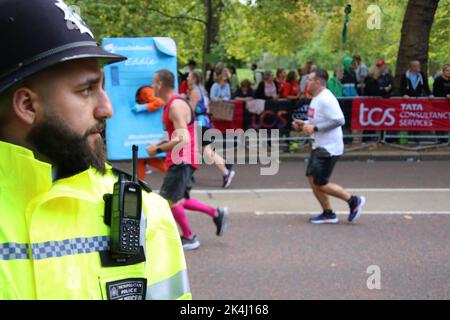 St. James Park & Birdcage Walk, Londra, Regno Unito. 10 ottobre 2022. Un retinue apparentemente infinito di corridori a media e bassa velocità procede lungo l’ultima tappa della London Marathon del 2022, percorrendo Birdcage Walk lungo il margine meridionale del St. James Park di Londra, Lungo il tragitto per girare intorno all'edificio frontale di Buckingham Palace e al traguardo situato lungo una famosa passeggiata, il London's Mall. Credit: ©Julia Mineeva/EGBN TV News/Alamy Live News Foto Stock