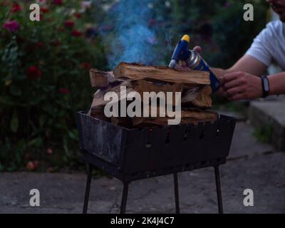 Legna che brucia nella griglia. Piccolo braciere pieghevole portatile  riempito di carboni per la cottura di carne, pesce, barbecue. Cucina alla  griglia all'aperto. Molla o Foto stock - Alamy