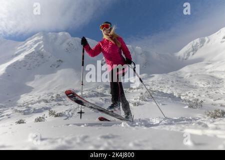 Sciatore di backcountry femminile che si appresta alla vetta di una vetta nevosa nei bassi Tatra in Slovacchia. Foto Stock