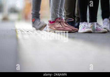 PRODUZIONE - 27 settembre 2022, Sassonia-Anhalt, Halle (Saale): Gli allievi di una classe di sesto grado presso la scuola secondaria Prof. otto Schmeil di Gröbers si trovano su una linea bianca sulla piattaforma della stazione centrale di Halle/Saale per la Giornata della prevenzione. Per molti anni, Deutsche Bahn, insieme alla polizia federale tedesca e ad altri partner, sta attuando un'ampia gamma di misure di prevenzione, tra cui sessioni di formazione direttamente presso le strutture a terra. Dal 2020 DB ha messo a punto dei propri team di prevenzione a tale scopo. (A dpa 'azioni pericolose per la vita presso gli impianti di binario: Deutsche Bahn focuse Foto Stock