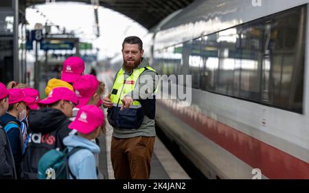 PRODUZIONE - 27 settembre 2022, Sassonia-Anhalt, Halle (Saale): Bastian Peter, responsabile della prevenzione della Deutsche Bahn, allena i bambini di una classe di sesto grado alla scuola secondaria Prof. otto Schmeil di Gröbers per una giornata di prevenzione alla stazione centrale di Halle/Saale. Per molti anni, Deutsche Bahn, insieme alla polizia federale tedesca e ad altri partner, sta attuando un'ampia gamma di misure di prevenzione, tra cui sessioni di formazione direttamente presso le strutture a terra. Dal 2020 DB ha messo a punto dei propri team di prevenzione a tale scopo. (A dpa 'azioni potenzialmente letali in pista facilitie Foto Stock