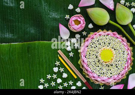Il krathong petalo di loto rosa decora con il suo polline, fiore della corona, bastone dell'incenso e candela per la luna piena della Thailandia o festival di Loy Krathong sulla banana Foto Stock
