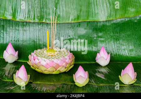 Il krathong petalo di loto rosa decora con il suo polline, fiore della corona, bastone dell'incenso e candela per la luna piena della Thailandia o festival di Loy Krathong sulla banana Foto Stock