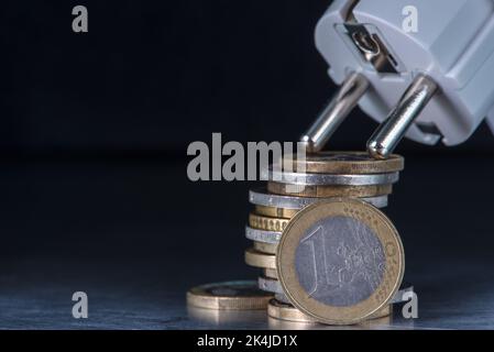 Concetto di aumento dei prezzi dell'elettricità, cumulo di monete in euro e presa elettrica con spazio copia Foto Stock