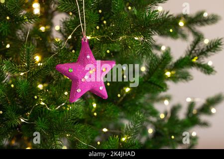 Bambini natale mestiere appeso su albero di Natale con le luci. Foto Stock