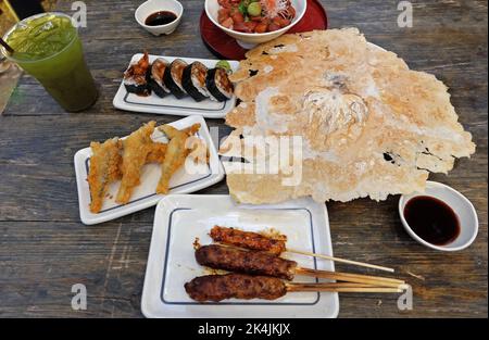 Izakaya (cibo di strada in stile giapponese) spiedini di pollo teriyaki, pesce volante fritto, panini Sushi Maki, Kaisen Don (ciotola di riso Sashimi), Senbei Foto Stock