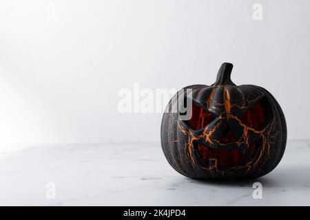 Zucca di Halloween nera su sfondo di marmo bianco Foto Stock