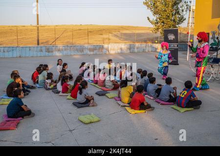 Batman, Turchia. 02nd Ott 2022. I clown pre-film intrattengono i bambini nel giardino della scuola. Batman Culture and Art Association organizza un evento cinematografico che introduce il cinema ai bambini che non hanno ancora conosciuto il cinema a Batman e nei villaggi dei suoi quartieri. L'associazione porta il film d'animazione di Hayao Miyazaki 'My Neighbor Totoro' nei villaggi come un doppiaggio curdo. Credit: SOPA Images Limited/Alamy Live News Foto Stock