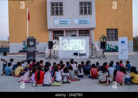 Batman, Turchia. 02nd Ott 2022. I bambini guardano attentamente il film animato nella loro lingua madre nel giardino della scuola. Batman Culture and Art Association organizza un evento cinematografico che introduce il cinema ai bambini che non hanno ancora conosciuto il cinema a Batman e nei villaggi dei suoi quartieri. L'associazione porta il film d'animazione di Hayao Miyazaki 'My Neighbor Totoro' nei villaggi come un doppiaggio curdo. (Foto di Bilal Seckin/SOPA Images/Sipa USA) Credit: Sipa USA/Alamy Live News Foto Stock