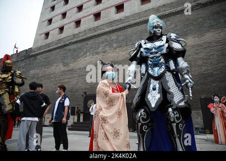 XI'AN, CINA - 1 OTTOBRE 2022 - i turisti posano con un 'Guerriero' di Mecha 2,7 metri di altezza navigando alla porta di Yongning del Muro della città di Xi'an a Xi'an, Shaanxi Foto Stock