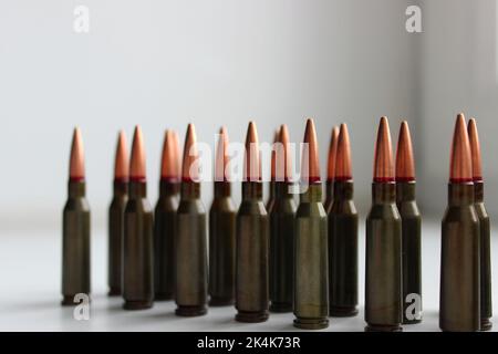 Munizioni dal vivo per fucile d'assalto con segno rosso su un proiettile in una fila sulla superficie bianca dettagliata vista laterale foto stock Foto Stock