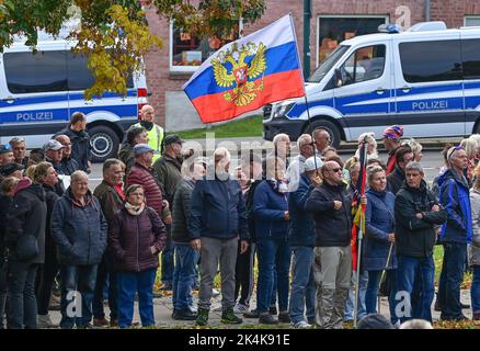 Brandeburgo, Francoforte (Oder): 03 ottobre 2022, le persone con bandiera russa partecipano ad una manifestazione nel centro della città. Dietro di loro si trovano i veicoli della polizia. L'occasione è stata la crisi energetica, la guerra in Ucraina e la politica di Corona. Con tamburi, fischi e bandiere tedesche e russe, marciarono per il centro della città nel giorno dell'unità tedesca e chiesero, tra le altre cose, di porre fine alle sanzioni contro la Russia. Foto: Patrick Pleul/dpa Foto Stock