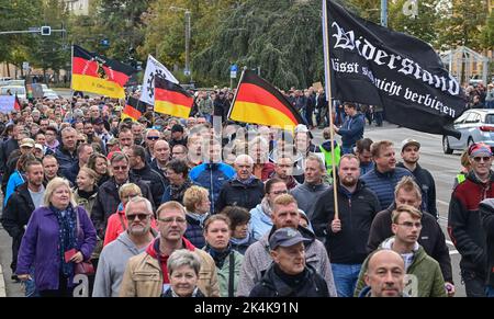 Brandeburgo, Francoforte (Oder): 03 ottobre 2022, la gente partecipa a una manifestazione nel centro della città. Un uomo porta una bandiera nera con l'iscrizione "la resistenza non può essere vietata". L'occasione è stata la crisi energetica, la guerra in Ucraina e la politica di Corona. Con tamburi, fischi e bandiere tedesche e russe, marciarono per il centro della città nel giorno dell'unità tedesca e chiesero, tra le altre cose, di porre fine alle sanzioni contro la Russia. Foto: Patrick Pleul/dpa Foto Stock