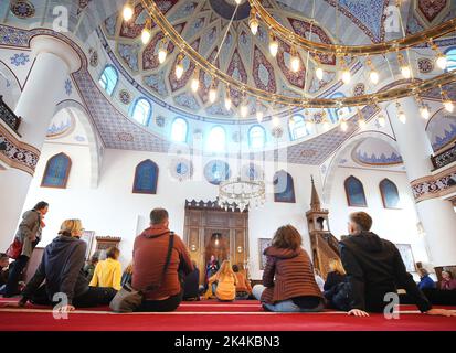 Duisburg, Germania. 03rd Ott 2022. I visitatori della moschea Merkez il giorno della moschea aperta hanno Hülya Ceylan (M) a spiegare loro i locali. La Giornata della Moschea aperta è stata celebrata nel giorno dell'unità tedesca dal 1997. Sotto gli auspici del Consiglio di coordinamento dei musulmani (KRM), circa 1.000 comunità della moschea in tutta la Germania stanno nuovamente aprendo le porte quest'anno per consentire a musulmani e non musulmani di conoscersi e scambiarsi idee. Nella Renania settentrionale-Vestfalia, dove vive un numero particolarmente elevato di musulmani, partecipano anche molte moschee. Credit: Roland Weihrauch/dpa/Alamy Live News Foto Stock