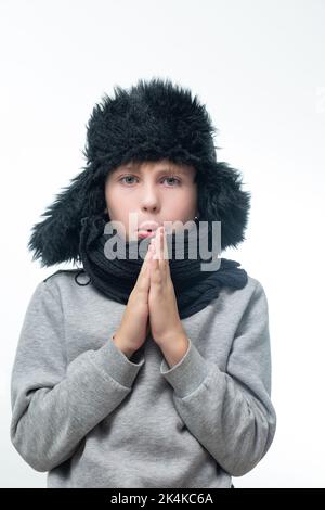 Cappello invernale con foulard e sciarpa, ritratto di un ragazzo in abiti invernali. Foto Stock