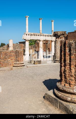 Colonne in marmo che sostengono l'antica facciata del tempio romano nell'antica città di Pompei Foto Stock