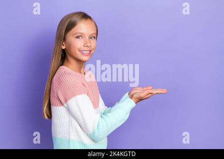 Profilo lato foto di soddisfatto positivo ragazza toothy sorriso trendy jumper due braccio presente spazio vuoto isolato su sfondo di colore viola Foto Stock