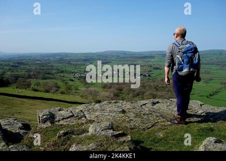 Uomo che ammira la vista di Barbon da Devil's Crag sulla strada per il Mountain Castle Knott tra lo Yorkshire Dales & Lakes National Park, Inghilterra. Foto Stock