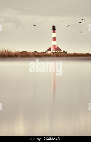 Faro Westerhesversand riflessione in acqua. Foto di alta qualità Foto Stock