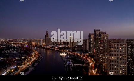 Punto di riferimento lungo il fiume Haihe a Tianjin, Cina, che include blocchi creativi e centri commerciali, nonché vari ponti tra cui il Ponte Guotai. Foto Stock