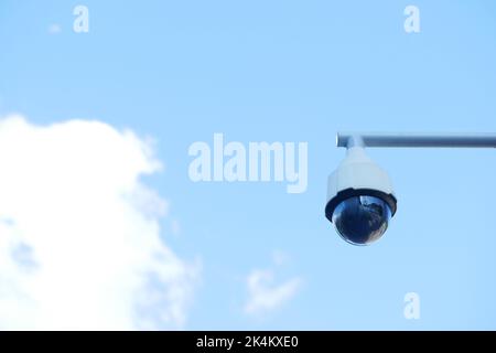 Telecamera di sicurezza CCTV che opera contro il cielo blu Foto Stock