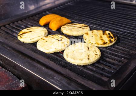 Arepas colombiani e empanadas alla griglia. Cucina tradizionale colombiana Foto Stock