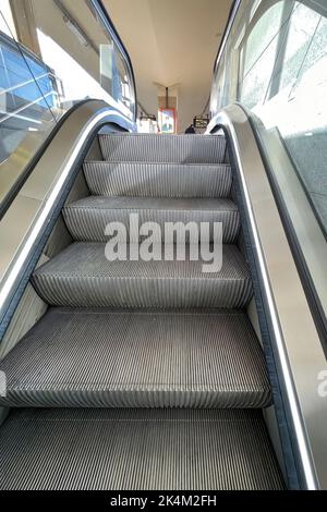 Primo piano verticale su una scala mobile lenta in alluminio elettrica pedone verso l'alto nella stazione della metropolitana ferroviaria Foto Stock