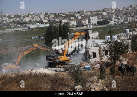 Hebron, città della Cisgiordania di Hebron. 3rd Ott 2022. I bulldozer israeliani demoliscono una casa palestinese, che si ritiene sia stata costruita senza permesso, nella città della Cisgiordania di Hebron, 3 ottobre 2022. Credit: Mamoun Wazwaz/Xinhua/Alamy Live News Foto Stock