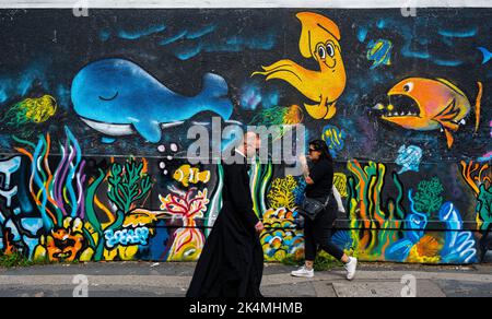 Persone che camminano accanto Graffiti a Brighton North Laines Foto Stock