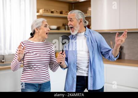 Pensione felice. Sposi anziani gioiosi che si divertono insieme a casa Foto Stock