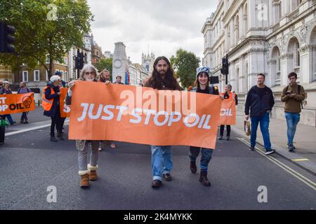 Londra, Regno Unito. 03rd Ott 2022. I manifestanti marciano con un banner Just Stop Oil a Whitehall durante la dimostrazione. La protesta si è inserita in una serie di manifestazioni che si sono svolte quotidianamente a Westminster, con il gruppo d'azione sul clima che chiede di porre fine ai combustibili fossili e di passare alle energie rinnovabili. Credit: SOPA Images Limited/Alamy Live News Foto Stock