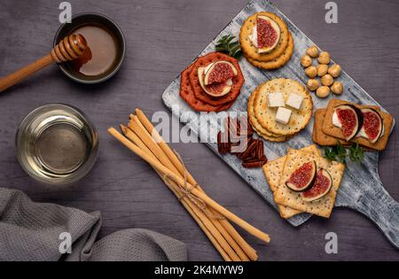 Fotografia alimentare di vino, formaggio fresco, salame, fichi, cracker, feta, grissini Foto Stock