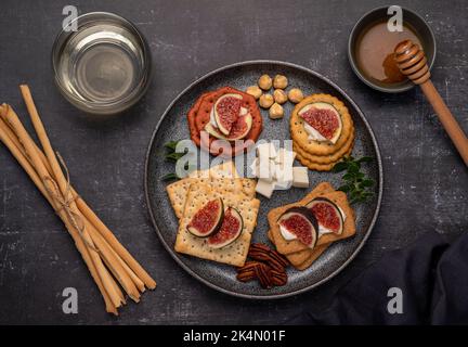 Fotografia alimentare di vino, formaggio fresco, salame, fichi, cracker, feta, grissini Foto Stock