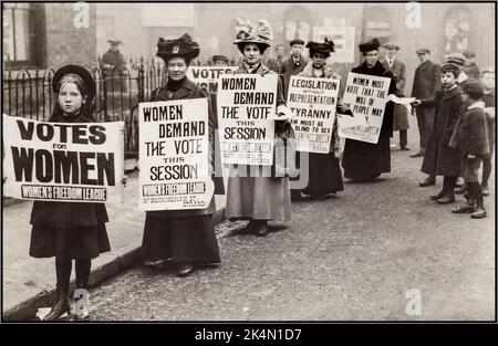 1900s movimento Suffragette Donne con striscioni che chiedono 'Voti per le Donne' Gran Bretagna dimostrazione di strada a suffragio britannico con striscioni e bambini che interagiscono e aiutano con dimostranti e suffragette Regno Unito ''LE DONNE CHIEDONO IL VOTO' ''Women Freedom League' Foto Stock