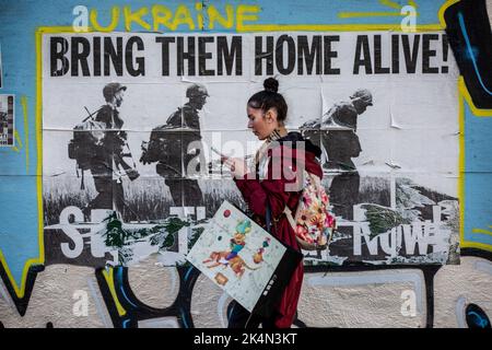 Kiev, Ucraina. 24th Set, 2022. Una ragazza passa davanti al poster con l'iscrizione "porta a casa viva" nel centro di Kyiv. Ogni giorno muoiono in media 50 soldati ucraini in battaglia con l'esercito russo. (Foto di Oleksii Chumachenko/SOPA Images/Sipa USA) Credit: Sipa USA/Alamy Live News Foto Stock