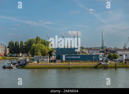 Rotterdam, Paesi Bassi - 11 luglio 2022: Trasloco e trasporto Condor a Sint-Janshaven con vicini come LA sua Rotterdam sotto il paesaggio blu. Foto Stock