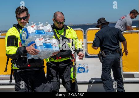 Il personale della Guardia Costiera proveniente dai team degli scioperi del Golfo, dell'Atlantico e del Pacifico trasporta risorse per assistere la popolazione di Sanibel Island, Florida, 30 settembre 2022. Le squadre di sciopero hanno condotto operazioni di ricerca e salvataggio dopo che l'uragano Ian ha sbarcato nella zona. (STATI UNITI Guardia costiera foto di Petty Officer 3rd Classe Gabriel Wisdom) Foto Stock