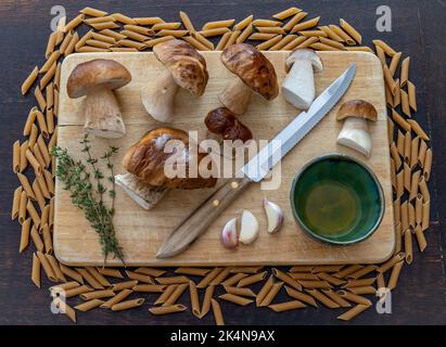 Ingredienti per un delizioso piatto composto da porcini al boleto, pasta, aglio e rosmarino Foto Stock
